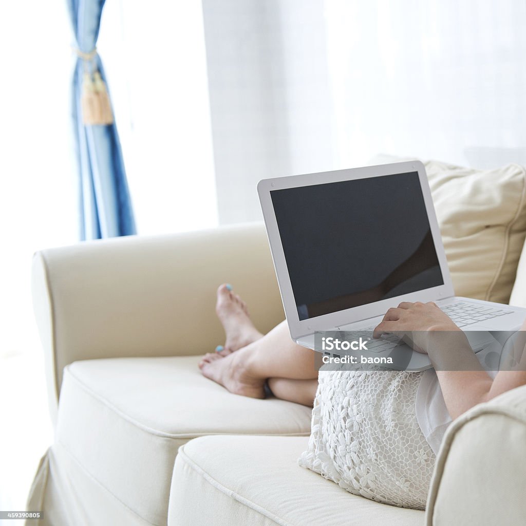 using laptop on sofa young asian woman using laptop on sofa. Adult Stock Photo