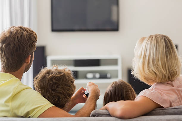 istock Family watching television on a couch 459391079