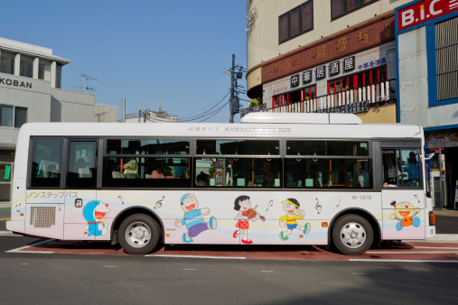 Kawasaki, Japan - September 29, 2011 : Passengers inside the Kawasaki City Bus. This bus parked at Noborito Station in Kawasaki, Japan. This bus is going to Fujiko-F-Fujio Museum. Many different cartoon characters are displayed on the bus.