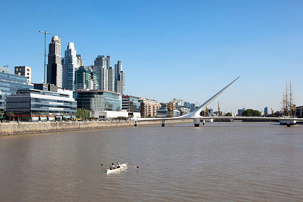 Summertime in Puerto Madero, Buenos Aires, Argentina Buenos Aires, Argentina - December 14, 2010:  Canoeing is a popular pasttime in the Puerto Madero district, with calm waters  people enjoy the sights such as the Puente de la Mujer bridge.  This bridge is also known as Bridge of Women. puente de la mujer stock pictures, royalty-free photos & images