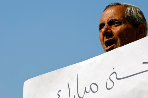 Cairo, Egypt - February 2, 2011: Several days into the 18 days of anti-government demonstrations that would lead to the resignation of President Hosni Mubarak, pro-Mubarak demonstrators were mobilized for a counter-demonstration. Here a man holds a sign in support of Mubarak.