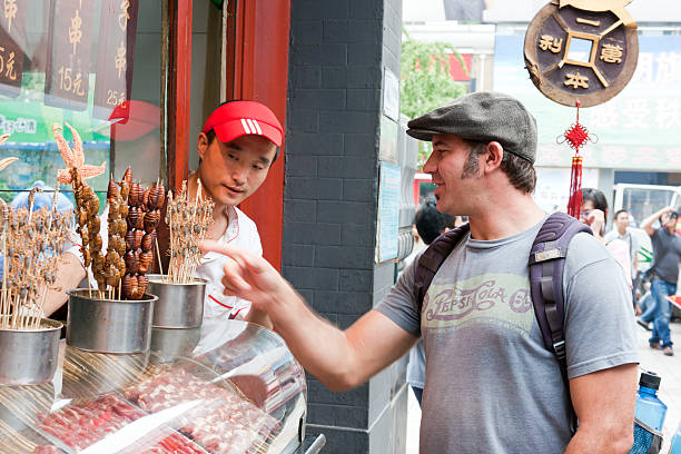 西洋の観光したスナックをお楽しみください。 - food chinese ethnicity street china ストックフォトと画像