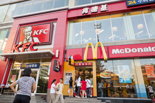 Shenzhen, China - October 15, 2011: People in front of KFC and McDonald's fast food restaurants in one building of Shenzhen, Guangdong province, China.