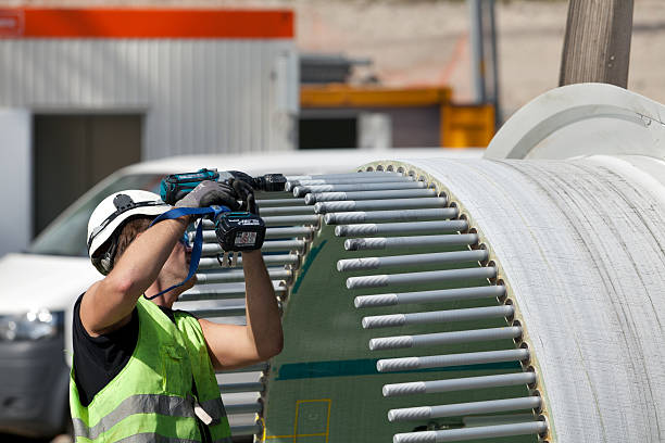 Trabalhador no local de construção de uma turbina eólica - fotografia de stock