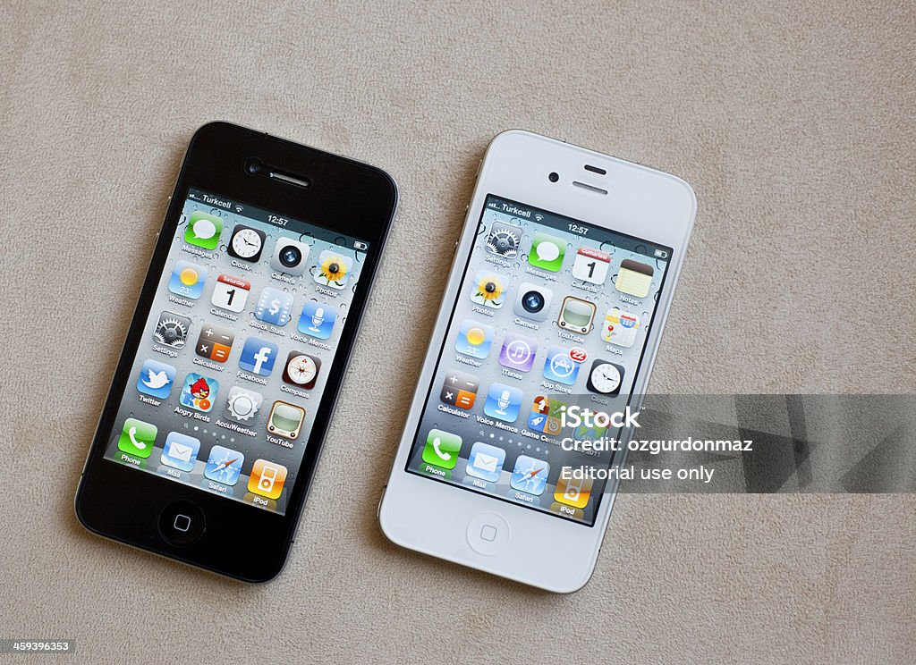 Black And White Versions Of iPhone4 Antalya, Turkey - October 1, 2011: Black And White Versions Of iPhone4 on a plain background. Both are showing their home screens. iPhone is produced by Apple Inc. Apple Computers Stock Photo