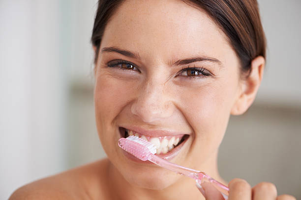 Brushing teeth can be exhilerating A gorgeous young brunette brushing her teeth in the morning human teeth stock pictures, royalty-free photos & images