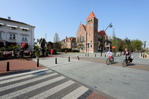Zeist, the Netherlands - April 10, 2009: The center of the town Zeist. A restaurant at the left and the town hall at the background in the middle of the picture. A woman and a boy are crossing the street. Zeist is located a few kilometers east of the city of Utrecht.