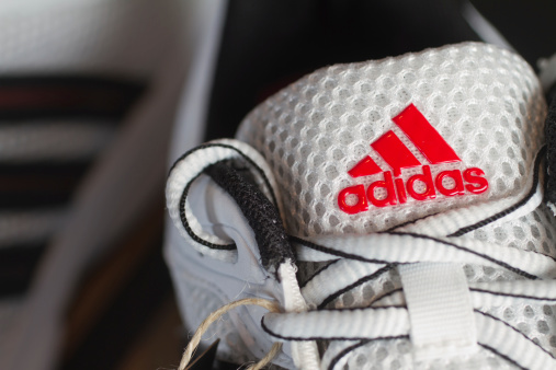 Fuerth, Germany - October 19, 2011: Red Adidas logo on a white nylon running shoe.Adidas AG is one of the leading sports apparel manufacturer in the world with their headquarter in Herzogenaurach, Germany. Adidas is also famous for its distinctive three stripes on the majority of all products.