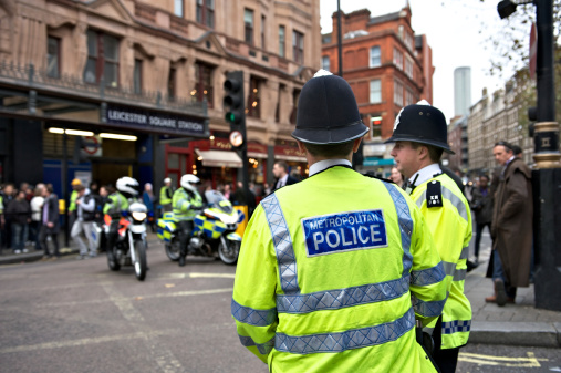 London, UK - 9th November, 2011:  Two London policemen standing by the roadside during a demonstration being held in Central London. Their motorcycle colleagues are positioned in the background.