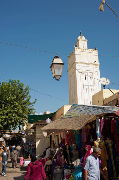 Semmarine Medina Fes, Morocco - October 8, 2011: People are walking and shopping in the bazaar near the gate Souk Semmarine MAdina. A minaret in the image too. bab boujeloud stock pictures, royalty-free photos & images
