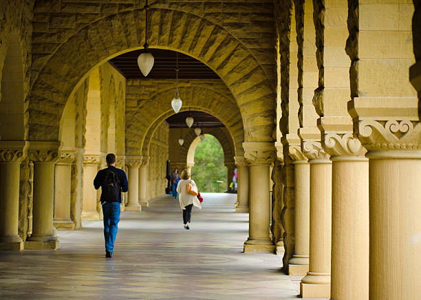 Students walk along covered footpath at Stanford University Stanford, United States - October 10, 2011: Students walk underneath a covered walkway at the Stanford University campus on their way to classes. Originally established in 1891, the university has over 15,000 students. stanford university photos stock pictures, royalty-free photos & images