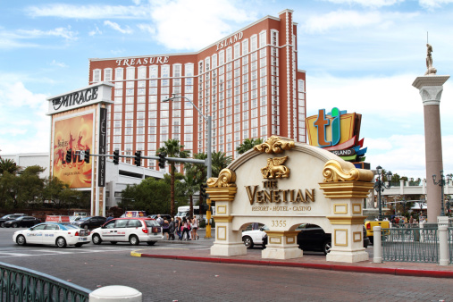Las Vegas, USA - May 19, 2011: This is a view of Las Vegas Boulevard in front of Treasure Island Resort and Casino in Las Vegas. Traffic and pedestrians can be seen on the Strip in front of the building. Marquee signs for the Mirage and the Venetian resorts are also in the scene.