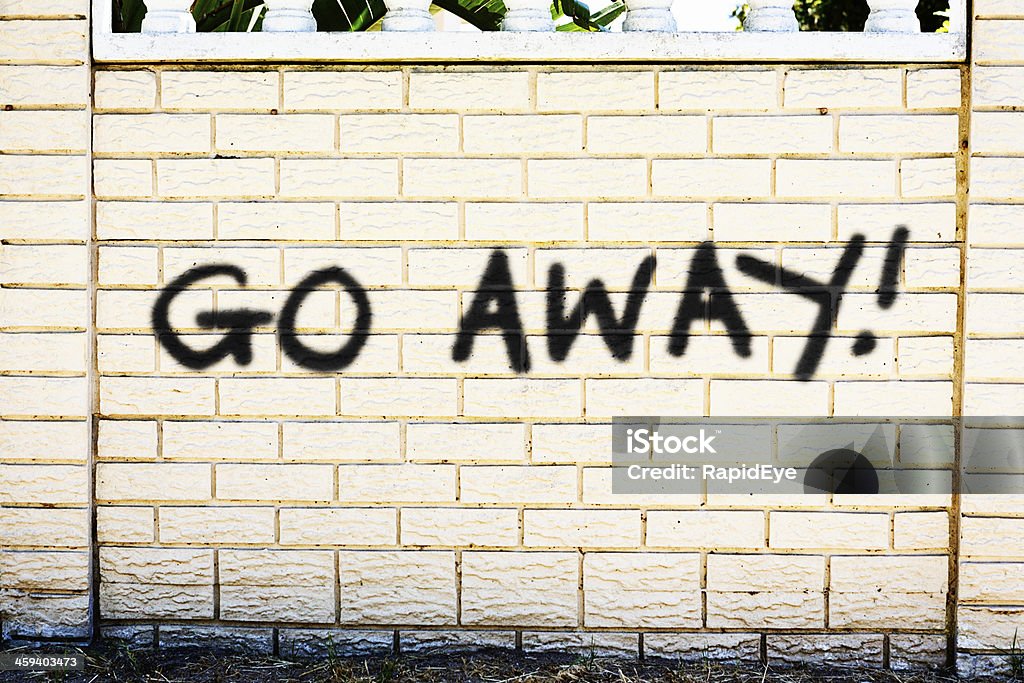 Go Away ! dit désagréable graffiti sur le mur de briques - Photo de Go Away - Petite phrase libre de droits