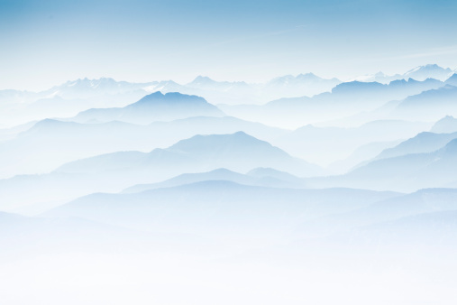 Aerial photo of the Bavarian Alps in the mist. High key mountain silhouettes.