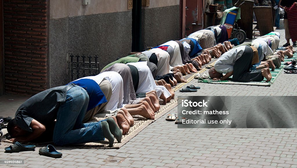Muslim men pray on a street Marrakesh, Morocco - August 8, 2010: Muslim men pray on a street in Marrakesh. Islam is the largest religion in Morocco. Adult Stock Photo
