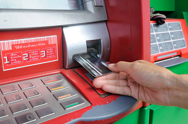istock insert card into an ATM to begin a financial transaction 459409757