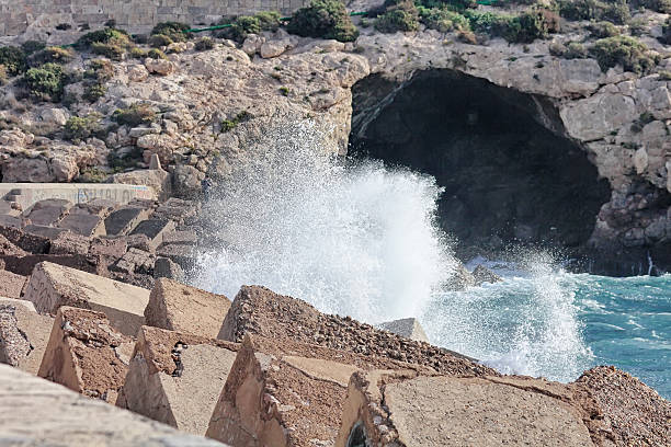 istock Large waves crashing and splashing on a seawall 459410427