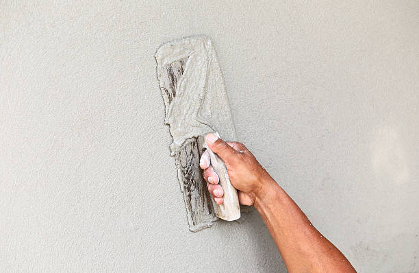 istock plasterer concrete worker at wall of house construction 459412157