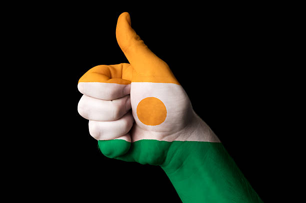Hand with thumb up gesture in colored niger national flag as symbol of excellence, achievement, good, - for tourism and touristic advertising, positive political, cultural, social management of country