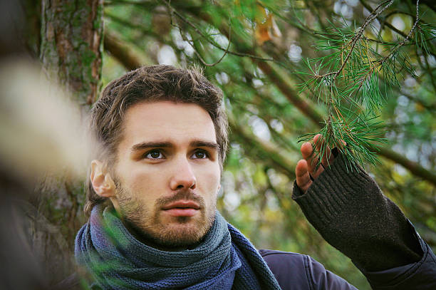 Beautiful male portrait outdoor near fir-tree