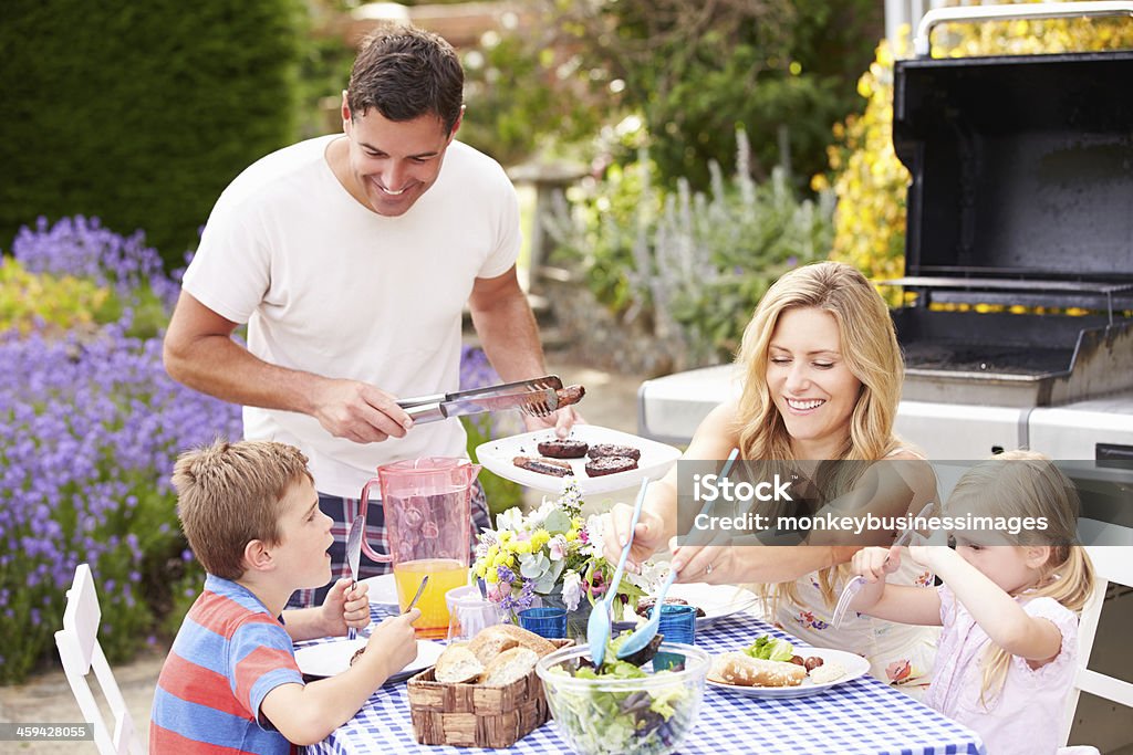 Disfrute al aire libre de la familia barbacoa en el jardín - Foto de stock de Parrillera libre de derechos