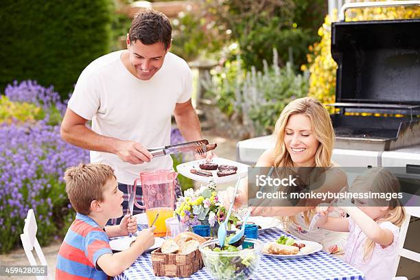 Disfrute Al Aire Libre De La Familia Barbacoa En El Jardín Foto de stock y más banco de imágenes de Parrillera