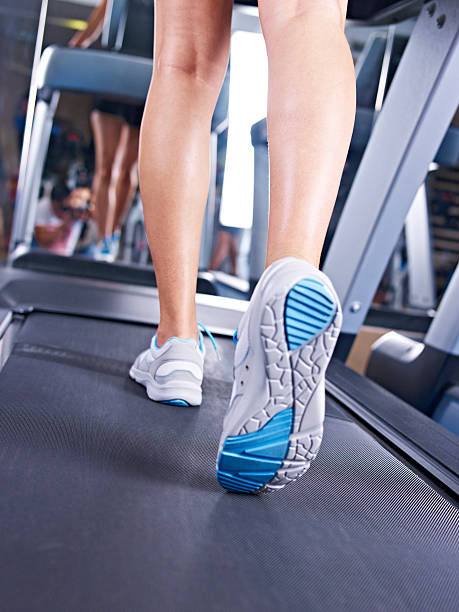 istock Closeup view of a woman's legs while she walks on treadmill 459428085