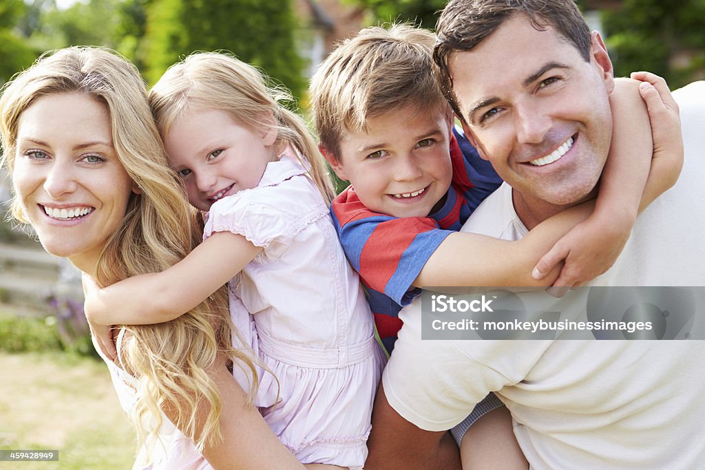 Retrato de família sorridente no jardim - Foto de stock de Família royalty-free