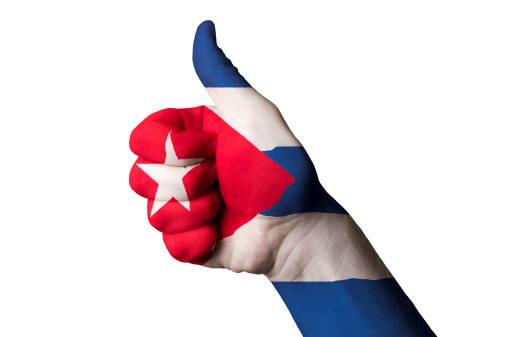 Hand with thumb up gesture in colored cuba national flag as symbol of excellence, achievement, good, - for tourism and touristic advertising, positive political, cultural, social management of country