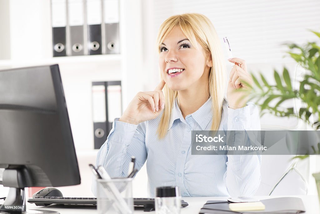Businesswoman Businesswoman in the office. Sitting at the table with computer and thinking.  Adult Stock Photo