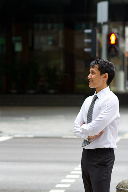 istock Young Asian Business man waiting beside a red traffic light 459432339