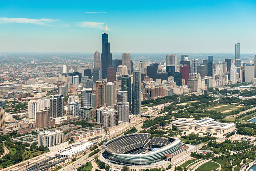 Chicago, Illinois, USA - July 12, 2013: Aerial view of the Chicago skyline with the Soldier Field stadium at the bottom of the image. This arena is the house of the Chicago Bears NFL football team. The stadium is situated on the east side of Chicago. It's also visible the Willis tower on the background. The tallest building on US up to 2013. The image has been taken from an Helicopter .