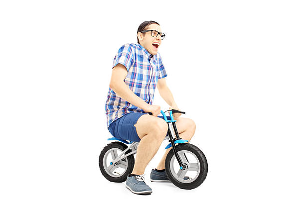 istock Excited young male riding a small bicycle 459434211
