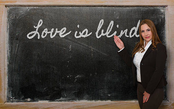 istock Teacher showing Love is blind on blackboard 459435933