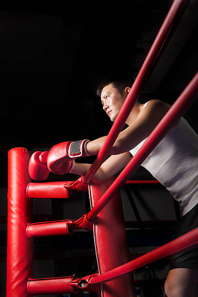 istock Serious male boxer resting his elbows on the ring side 459440643