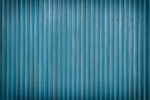 Cool Blue corrugated Metal and bolts Background with light vignette