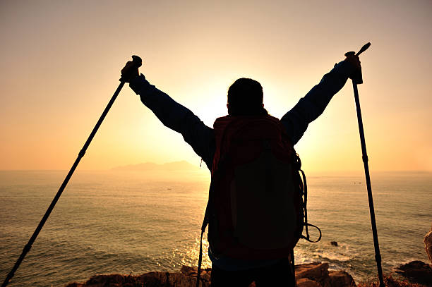 istock woman hiker open arms to sunrise 459441673