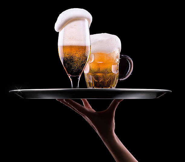 Two beer glasses with foam on a waiter tray