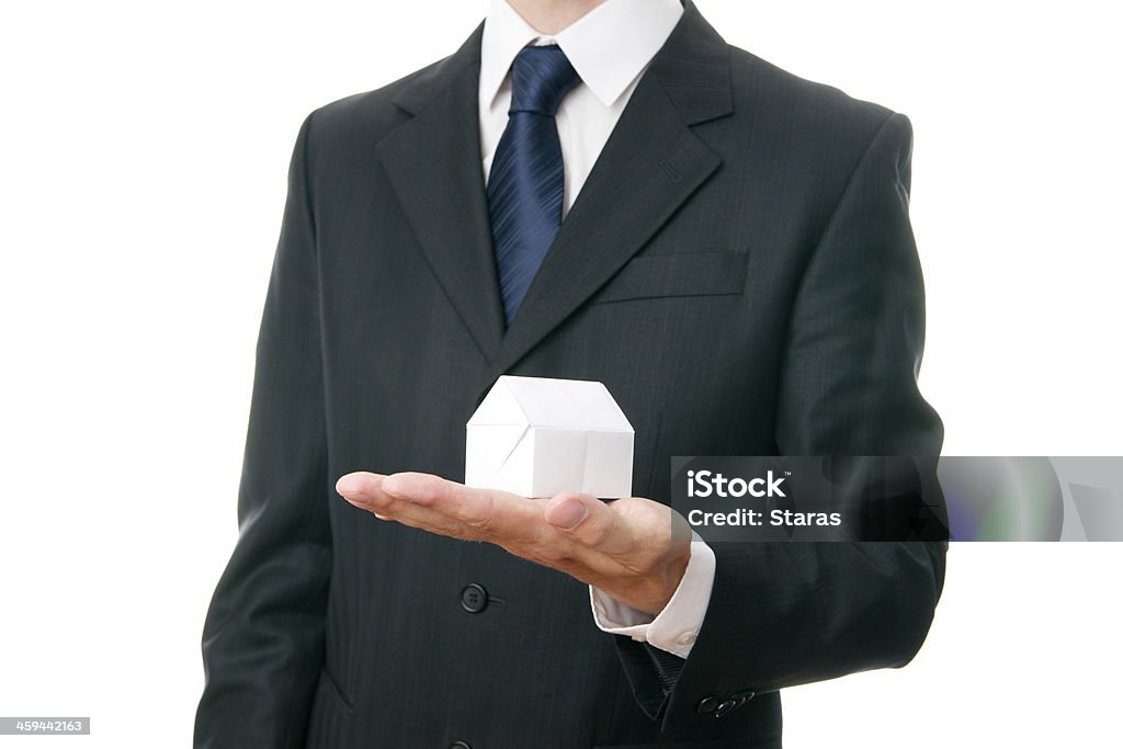 Paper house in the hand of a businessman Paper house in the hand of a businessman isolated on white background Adult Stock Photo