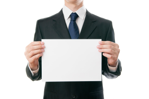 Businessman holding a piece of paper on a white background.