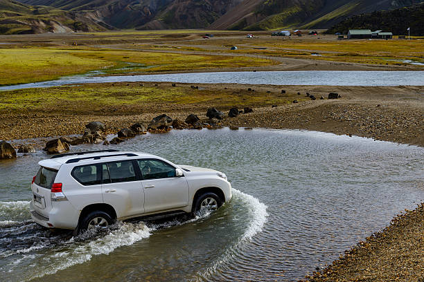 Landmannalaugar, Iceland - September 11, 2013: White Toyota Landcruiser 4x4 SUV driving through water Landmannalaugar in Iceland.