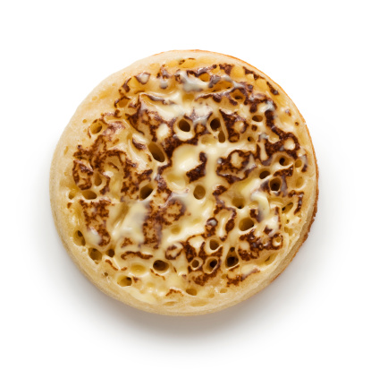 Crumpet with melting butter on a white background.