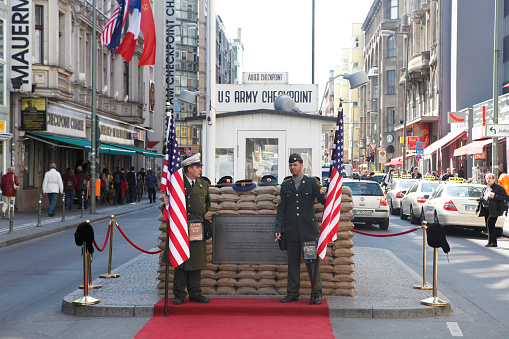 Berlin, Germany - April 23, 2012: Checkpoint Charlie was a famous crossing point on the border of West and East Berlin during the cold war, tourists can take a photo of posing soldiers in US uniforms there today.