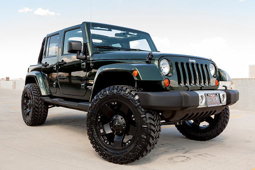 Scottsdale, United States - September 16, 2011: A parked green Jeep Wrangler, this particular Jeep has a custom lift kit and wheels.