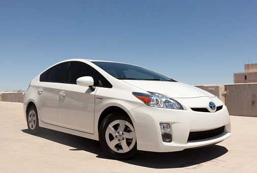 Scottsdale, United States - July 13, 2011: A photo of a parked white Toyota Prius sedan. The prius is a hybrid car, that runs on half gas and half electricity from batteries.