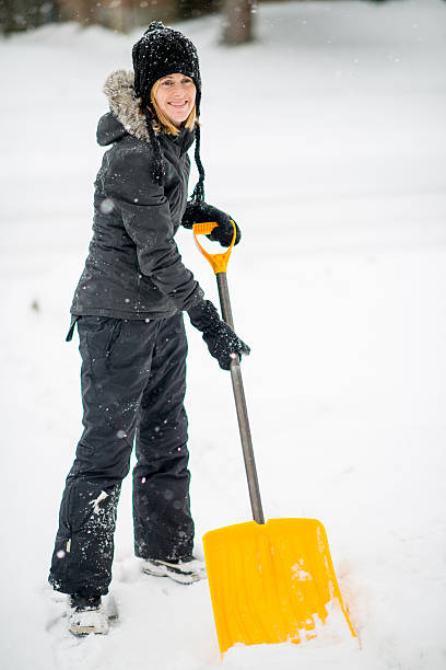 istock Shovelling snow off her driveway after a storm 459446279