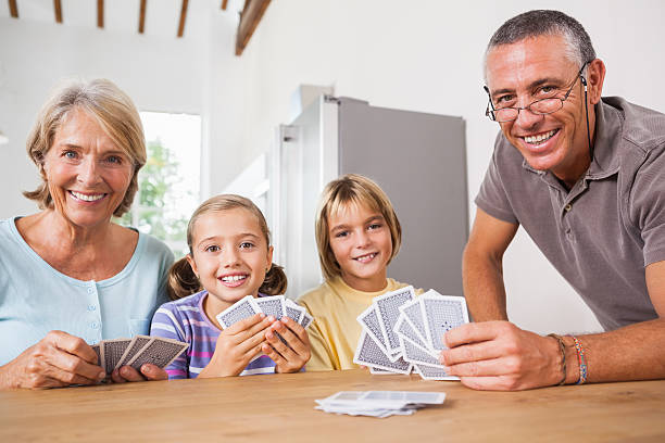 istock Smiling children playing cards with grandparents 459446577