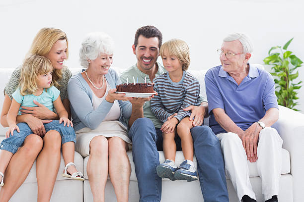 family smiling with a birthday cake - long life cake birthday cake grandparent 뉴스 사진 이미지