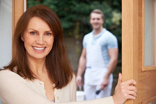 istock Woman Opening Door To Decorator 459454665
