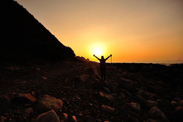 istock woman hiker open arms to sunrise 459455167